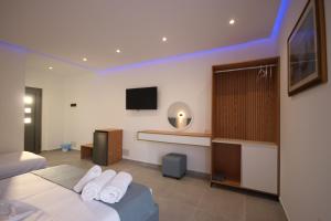 a hotel room with a bed and a tv at Bujtina Eleni in Himare