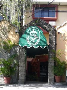 a green umbrella on the side of a building at Hotel Mediterraneo Plaza in San Salvador