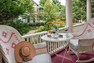 a porch with two chairs and a table with a bottle of wine at Spencer Hotel & Spa Chautauqua in Chautauqua