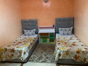 two beds sitting next to each other in a room at Appartement chez Elmehdi in Fès
