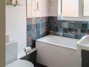 a bathroom with a tub and a toilet and a sink at Beach Oasis Cottage - Uk48530 in Margate