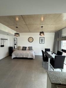 a bedroom with a bed and a table and a dining room at Apart - Nuevo Constitucion 4C - Frente al Mar in Mar del Plata
