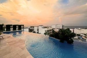 a swimming pool on the roof of a building at Coco Zen Studio king size bed sea view near Coco Beach PDC in Playa del Carmen