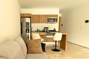 a kitchen with a stainless steel refrigerator and white chairs at Coco Zen Studio king size bed sea view near Coco Beach PDC in Playa del Carmen