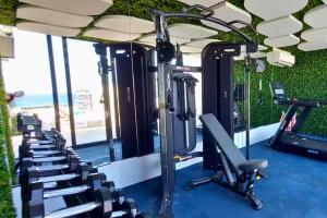 a gym with a row of tread machines at Coco Zen Studio king size bed sea view near Coco Beach PDC in Playa del Carmen