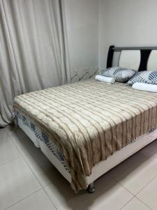 a bed with a blanket on it in a room at Centro de Brasília, 5 minutos da Esplanada dos Ministérios in Brasilia