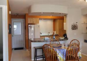 eine Küche mit einem Tisch mit Stühlen und einer Arbeitsplatte in der Unterkunft A Cozy - Spacious Urban Retreat - Child / Pet Friendly in Lethbridge