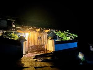 a wooden gate with a light on it at night at Carpe Diem Kamaida in Ochi