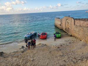 three cars parked on the beach next to the ocean at Evelin's On The Beach in Montego Bay