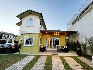 a yellow and white house with a patio at C&G Staycation Home in General Trias