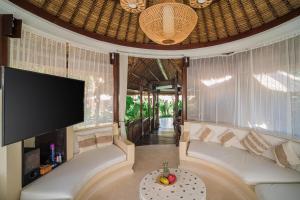 Una sala de estar con un sofá y un televisor de pantalla plana. en Villa Coconut Heaven by Bali Villa Solutions, en Seminyak 97 fotos más