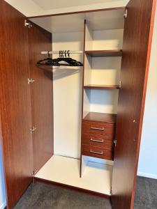 Un armario con una puerta de madera y un cajón de madera. en Plantation apartment, en Wanaka 6 fotos más