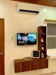 a living room with a flat screen tv on the wall at J & A Homestay 