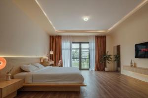 a bedroom with a bed and a large window at Homestay & Hotel Concept Maison in Quang Tri