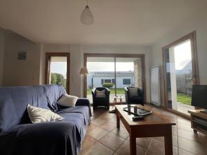 ein Wohnzimmer mit einem blauen Sofa und einem Tisch in der Unterkunft Maison 7 pers, proche plage et centre Arzon, jardin calme - FR-1-775-33 in Arzon