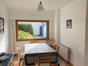 ein Esszimmer mit einem Tisch und einem Fenster in der Unterkunft Maison 7 pers, proche plage et centre Arzon, jardin calme - FR-1-775-33 in Arzon
