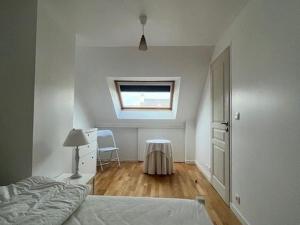 ein weißes Schlafzimmer mit einem Bett und einem Fenster in der Unterkunft Maison 7 pers, proche plage et centre Arzon, jardin calme - FR-1-775-33 in Arzon