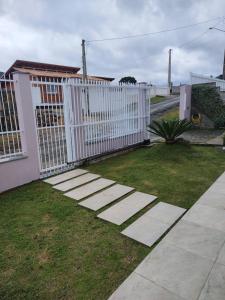 a white fence in front of a house at Refúgio aconchegante no coração de Urubici in Urubici +2 photos