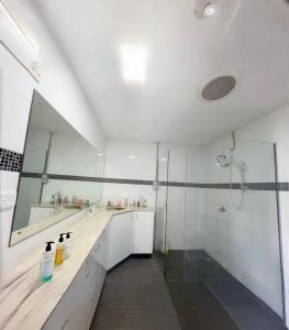 un bagno bianco con doccia e lavandino di Fiji Sky City近機場商圈可做飯有冷氣 a Nadi
