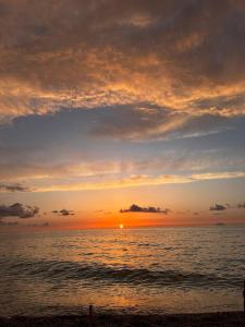 un tramonto sull'oceano con il sole che tramonta di Appartamento Franca a Capo dʼOrlando Altre 9 foto