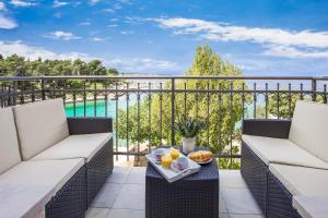 a balcony with two chairs and a tray of food on a table at Apartments & Rooms Milcetic M in Malinska