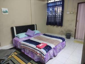 a bedroom with a bed with a quilt on it at Homestay Melaka Murah in Kampong Bertam