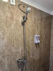a shower with a shower head in a bathroom at Alit Guest House in Uluwatu