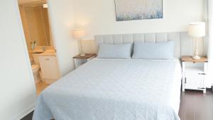 a bedroom with a bed with a blue comforter at Pantages Skyline Suite in Toronto Centre - Free Parking in Toronto