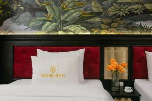 a hotel room with a bed with a red headboard at Grand Hanoi Hotel in Hà Ðông +19 photos