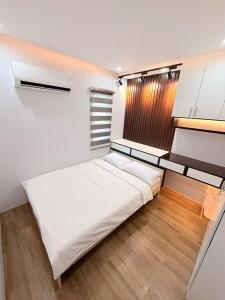 a bedroom with a large white bed and a window at 2Js VILLA in Bantug +20 photos
