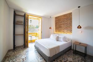 サレントにあるCasa Serafin Hotelのベッドとレンガの壁がある寝室