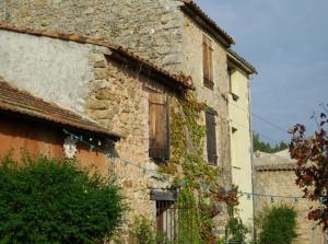 an old stone building with ivy growing on it at Les Gîtes du Lac in Montauroux