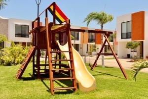 a playground with a slide in a yard at Privada, Casa Real Flamingos , Nayarit in Bucerías