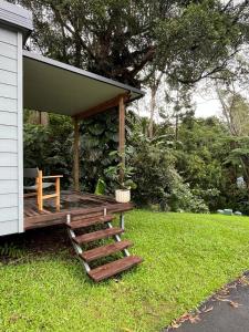 a house with a porch with a wooden deck at Cute and cosy 1 bedroom cabin in Mooloolah
