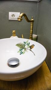 a sink with a gold faucet with a bird on it at La poale de munte in Vistisoara +35 photos