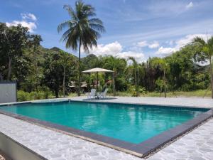 a swimming pool in a resort with a palm tree in the background at Kiang Khao Bungalow in Sam Roi Yot