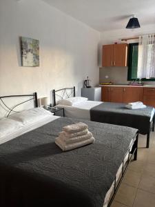a room with two beds with towels on a table at lazari Rooms in Himare