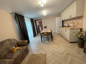 a living room with a couch and a table and a kitchen at Casuta din livada in Turda