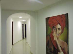 una pintura de una mujer con una bufanda roja en la pared en Apartamento Laguito Bocagrande, en Cartagena de Indias