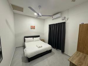 een kleine slaapkamer met een bed met een zwart gordijn bij D' Ehsan Homestay & Chalet in Kuala Terengganu +29 foto's