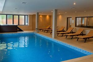 ein Hotelpool mit Stühlen und einem Fernseher in der Unterkunft Hrebet House in Borowez