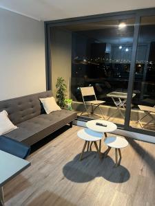 a living room with a couch and two tables and chairs at Santa Rosa del Mar, Departamento in Coquimbo