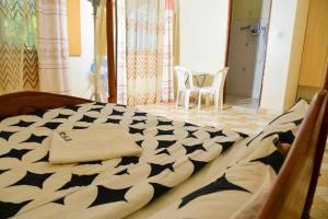 a bed with a black and white comforter in a room at Country Side Homes Kasese in Kasese