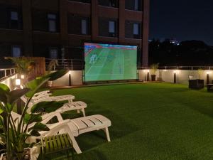 a large screen with a soccer game on a lawn at Bluedot Poshtel in Seoul +88 photos