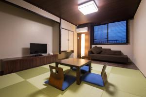 a living room with a table and a couch at Nasu Ichiya Hotel in Nasu
