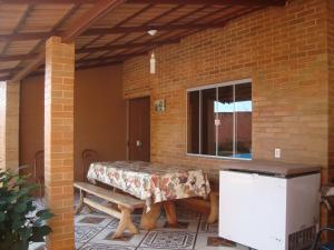 a patio with a table and a bench and a window at Casa Da Dona Selma in Pirenópolis