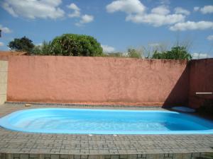 a blue swimming pool in front of a fence at Casa Da Dona Selma in Pirenópolis