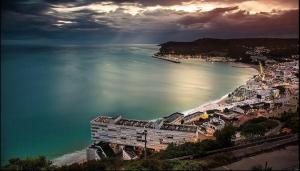 a view of a beach with a building and the ocean at Sesimbra Bay Apartment in Sesimbra