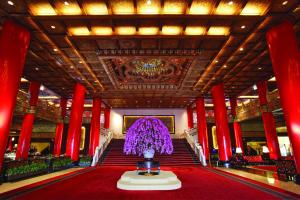a room with red columns and a staircase with purple flowers at The Grand Hotel in Taipei