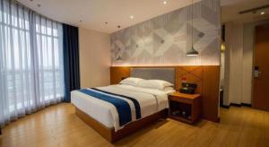 Postel nebo postele na pokoji v ubytování Borrman Hotel Shaoguan Nanxiong Rt-Mart